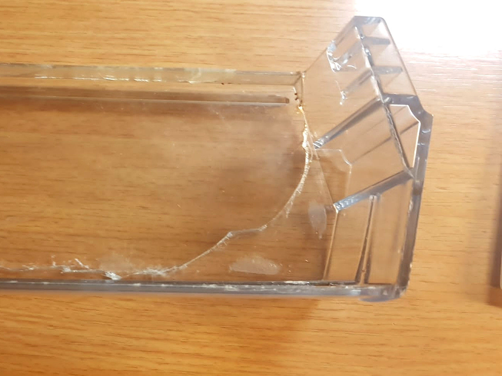 Gerissenes Kunststofffach im Kühlschrank vor der Reparatur